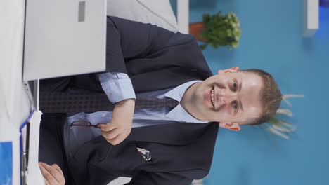 Vertical-video-of-Home-office-worker-man-smiling-at-camera.